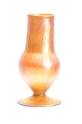 Lot 16 - A TIFFANY FAVRILE IRIDESCENT FOOTED BALUSTER...
