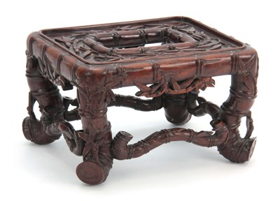 Lot 282 - A SMALL CHINESE HARDWOOD STAND having carved...