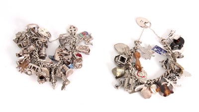 Lot 324 - TWO SILVER CHARM BRACELETS both with various...