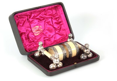 Lot 682 - A CASED SET OF IVORY AND WHITE METAL NAPKIN...