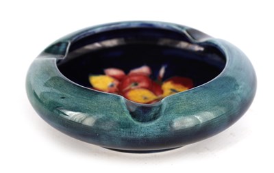 Lot 67 - A MOORCROFT CIRCULAR ASHTRAY WITH CURVED RIM...