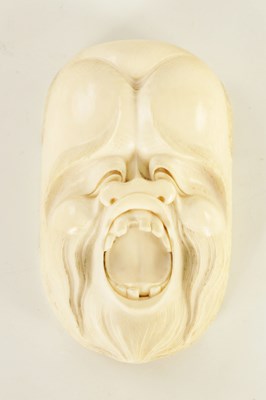 Lot 120 - A JAPANESE MEIJI PERIOD CARVED IVORY GROTESQUE FACE MARK