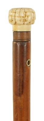 Lot 346 - A 19TH CENTURY CARVED IVORY AND MALACA ‘SEVEN FACES’ WALKING STICK