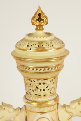 Lot 52 - AN ORNATE ROYAL WORCESTER GILT AND IVORY GROUND SCROLLED TWO-HANDLED CABINET VASE AND COVER
