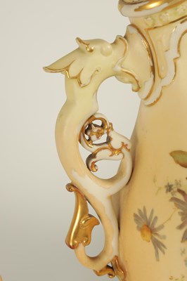 Lot 52 - AN ORNATE ROYAL WORCESTER GILT AND IVORY GROUND SCROLLED TWO-HANDLED CABINET VASE AND COVER