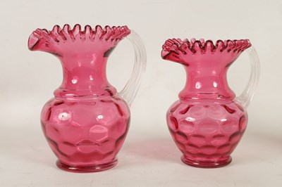 Lot 4 - A GRADUATED PAIR OF 19TH CENTURY STYLE OVERSIZED CRANBERRY GLASS JUGS