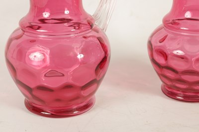 Lot 4 - A GRADUATED PAIR OF 19TH CENTURY STYLE OVERSIZED CRANBERRY GLASS JUGS