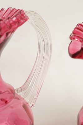 Lot 4 - A GRADUATED PAIR OF 19TH CENTURY STYLE OVERSIZED CRANBERRY GLASS JUGS
