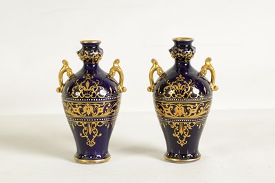 Lot 107 - A PAIR OF LATE 19TH CENTURY VIENNA STYLE GILT AND ROYAL BLUE GROUND TWO-HANDLED CABINET VASES