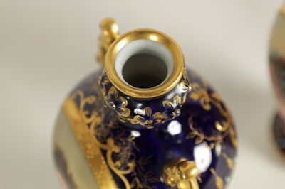 Lot 107 - A PAIR OF LATE 19TH CENTURY VIENNA STYLE GILT AND ROYAL BLUE GROUND TWO-HANDLED CABINET VASES
