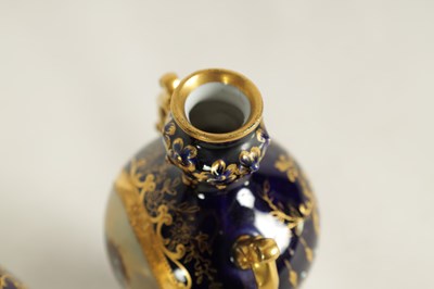 Lot 107 - A PAIR OF LATE 19TH CENTURY VIENNA STYLE GILT AND ROYAL BLUE GROUND TWO-HANDLED CABINET VASES