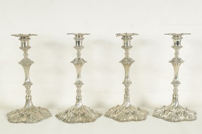 Lot 247 - A FINE SET OF FOUR GEORGE III LARGE CAST SILVER TABLE CANDLE STICKS IN THE ROCOCO MANNER