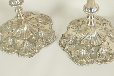 Lot 247 - A FINE SET OF FOUR GEORGE III LARGE CAST SILVER TABLE CANDLE STICKS IN THE ROCOCO MANNER