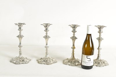 Lot 247 - A FINE SET OF FOUR GEORGE III LARGE CAST SILVER TABLE CANDLE STICKS IN THE ROCOCO MANNER