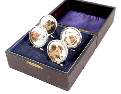 Lot 433 - A CASED SET OF FOUR CIRCULAR SILVER AND PAINTED DOG'S HEAD MENU HOLDERS