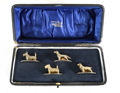 Lot 341 - A CASED SET OF FOUR SILVER GILT DOG MENU HOLDERS