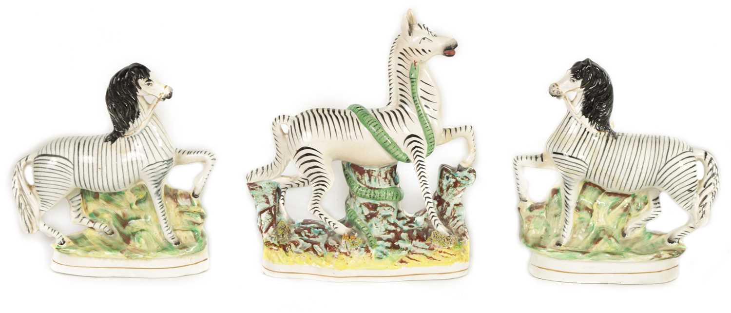 Lot 74 - A PAIR OF 19TH CENTURY STAFFORDSHIRE ZEBRAS AND A SIMILAR LARGER EXAMPLE