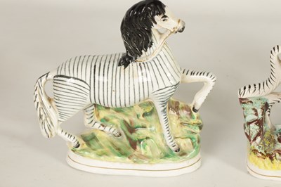 Lot 74 - A PAIR OF 19TH CENTURY STAFFORDSHIRE ZEBRAS AND A SIMILAR LARGER EXAMPLE