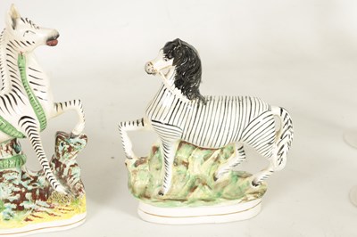 Lot 74 - A PAIR OF 19TH CENTURY STAFFORDSHIRE ZEBRAS AND A SIMILAR LARGER EXAMPLE