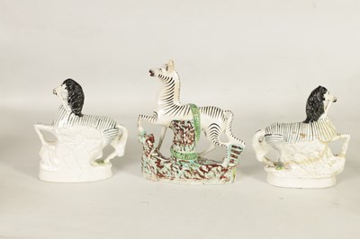 Lot 74 - A PAIR OF 19TH CENTURY STAFFORDSHIRE ZEBRAS AND A SIMILAR LARGER EXAMPLE