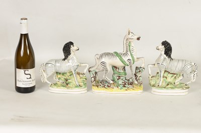 Lot 74 - A PAIR OF 19TH CENTURY STAFFORDSHIRE ZEBRAS AND A SIMILAR LARGER EXAMPLE