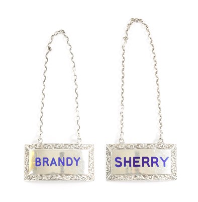 Lot 292 - A PAIR OF SILVER AND ENAMEL DECANTER LABELS FOR BRANDY AND SHERRY