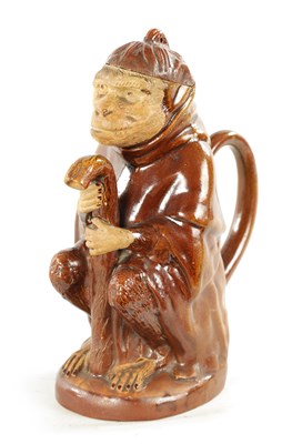 Lot 476 - A 19TH CENTURY POTTERY MONKEY PITCHER JUG