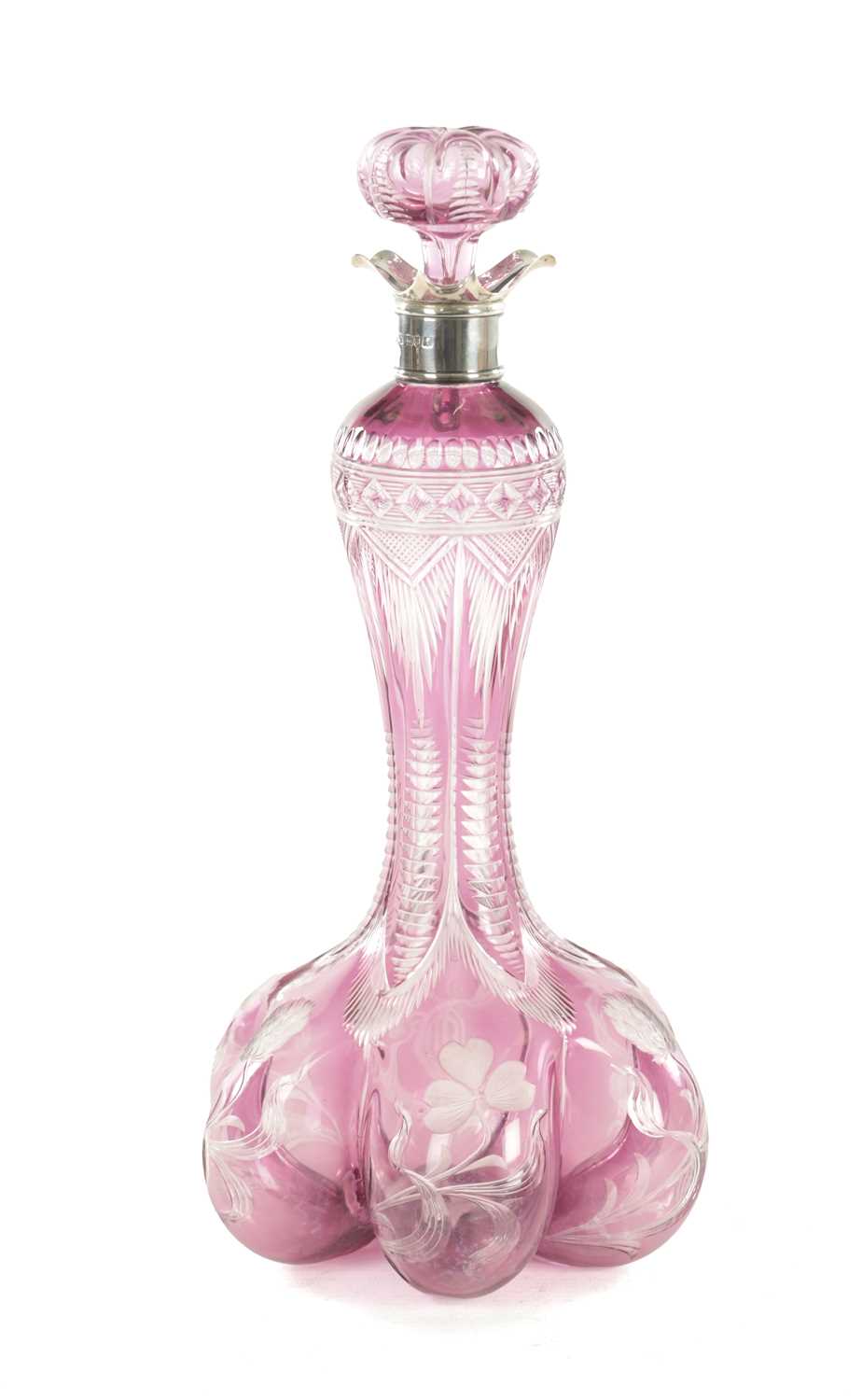 Lot 26 - ATTRIBUTED TO STEVENS AND WILLIAMS - AN INTAGLIO CUT GLASS AMETHYST TINTED DECANTER OF ORGANIC FORM OF 6 LOBES