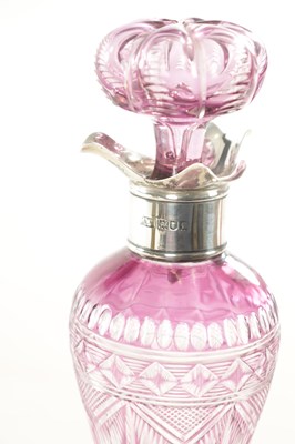 Lot 26 - ATTRIBUTED TO STEVENS AND WILLIAMS - AN INTAGLIO CUT GLASS AMETHYST TINTED DECANTER OF ORGANIC FORM OF 6 LOBES