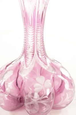 Lot 26 - ATTRIBUTED TO STEVENS AND WILLIAMS - AN INTAGLIO CUT GLASS AMETHYST TINTED DECANTER OF ORGANIC FORM OF 6 LOBES