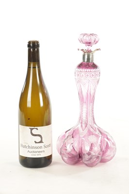 Lot 26 - ATTRIBUTED TO STEVENS AND WILLIAMS - AN INTAGLIO CUT GLASS AMETHYST TINTED DECANTER OF ORGANIC FORM OF 6 LOBES
