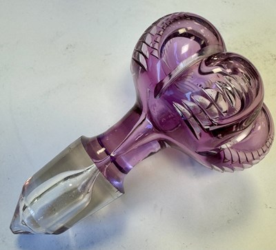 Lot 26 - ATTRIBUTED TO STEVENS AND WILLIAMS - AN INTAGLIO CUT GLASS AMETHYST TINTED DECANTER OF ORGANIC FORM OF 6 LOBES
