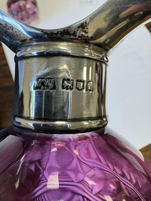 Lot 26 - ATTRIBUTED TO STEVENS AND WILLIAMS - AN INTAGLIO CUT GLASS AMETHYST TINTED DECANTER OF ORGANIC FORM OF 6 LOBES