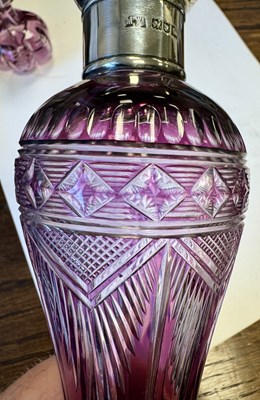 Lot 26 - ATTRIBUTED TO STEVENS AND WILLIAMS - AN INTAGLIO CUT GLASS AMETHYST TINTED DECANTER OF ORGANIC FORM OF 6 LOBES