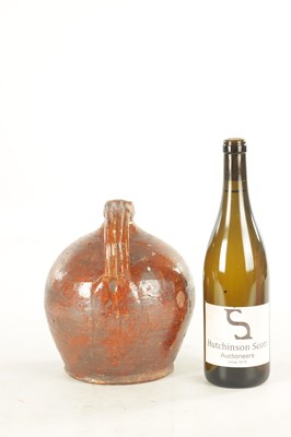 Lot 76 - AN EARLY BROWN GLAZED TERRACOTTA WINE JAR