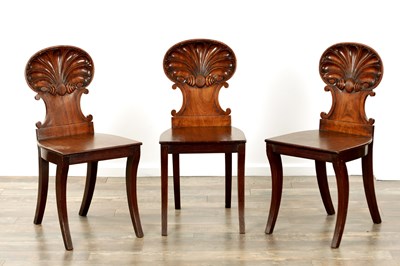 Lot 1235 - A SET OF THREE REGENCY MAHOGANY HALL CHAIRS IN THE MANNER OF GILLOWS