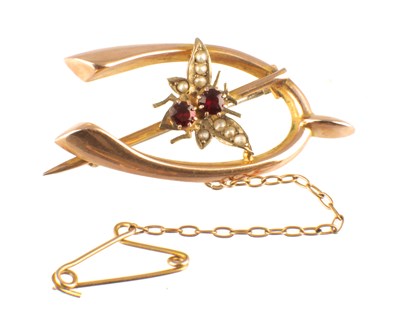 Lot 595 - A 9CT ROSE GOLD, GARNET AND PEARL WISHBONE SHAPED BROOCH