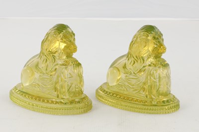 Lot 14 - A PAIR OF HENRY GREENER YELLOW PRESSED GLASS SCULPTURES OF SEATED LIONS