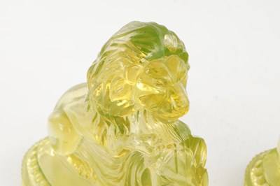 Lot 14 - A PAIR OF HENRY GREENER YELLOW PRESSED GLASS SCULPTURES OF SEATED LIONS