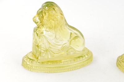Lot 14 - A PAIR OF HENRY GREENER YELLOW PRESSED GLASS SCULPTURES OF SEATED LIONS