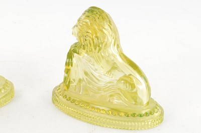 Lot 14 - A PAIR OF HENRY GREENER YELLOW PRESSED GLASS SCULPTURES OF SEATED LIONS