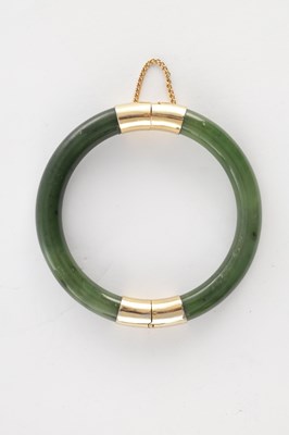 Lot 178 - AN ORIENTAL SAGE GREEN JADE AND GOLD METAL MOUNTED BANGEL