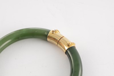 Lot 178 - AN ORIENTAL SAGE GREEN JADE AND GOLD METAL MOUNTED BANGEL
