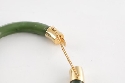 Lot 178 - AN ORIENTAL SAGE GREEN JADE AND GOLD METAL MOUNTED BANGEL