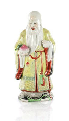 Lot 1719 - AN EARLY 20TH CENTURY CHINESE PORCELAIN FIGURE OF AN ELDER HOLDING FRUIT