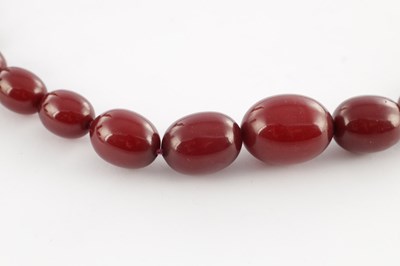 Lot 172 - A GRADUATED CHERRY AMBER OVAL BEAD NECKLACE