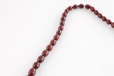 Lot 172 - A GRADUATED CHERRY AMBER OVAL BEAD NECKLACE
