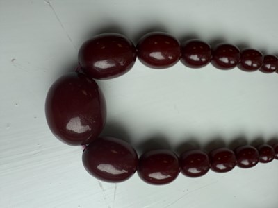 Lot 172 - A GRADUATED CHERRY AMBER OVAL BEAD NECKLACE
