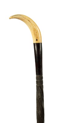 Lot 383 - AN AFRICAN CARVED HARDWOOD STICK WITH BOARS TUSK HANDLE
