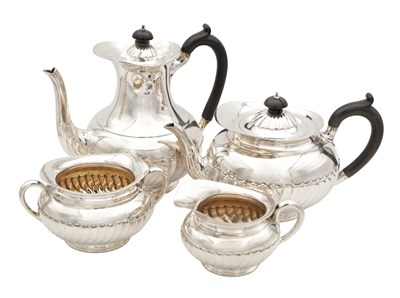 Lot 162 - AN EARLY 20TH CENTURY ENGLISH SILVER FOUR-PIECE TEA SERVICE WITH RIBBED LOWER BODIES AND EBONISED HANDLES